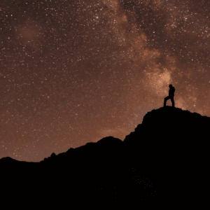 man on a hill starring at the stars