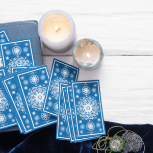 blue tarot cards spread on a white table with candles