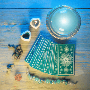 stack of blue tarot cards on a wooden table surronded by trinkets