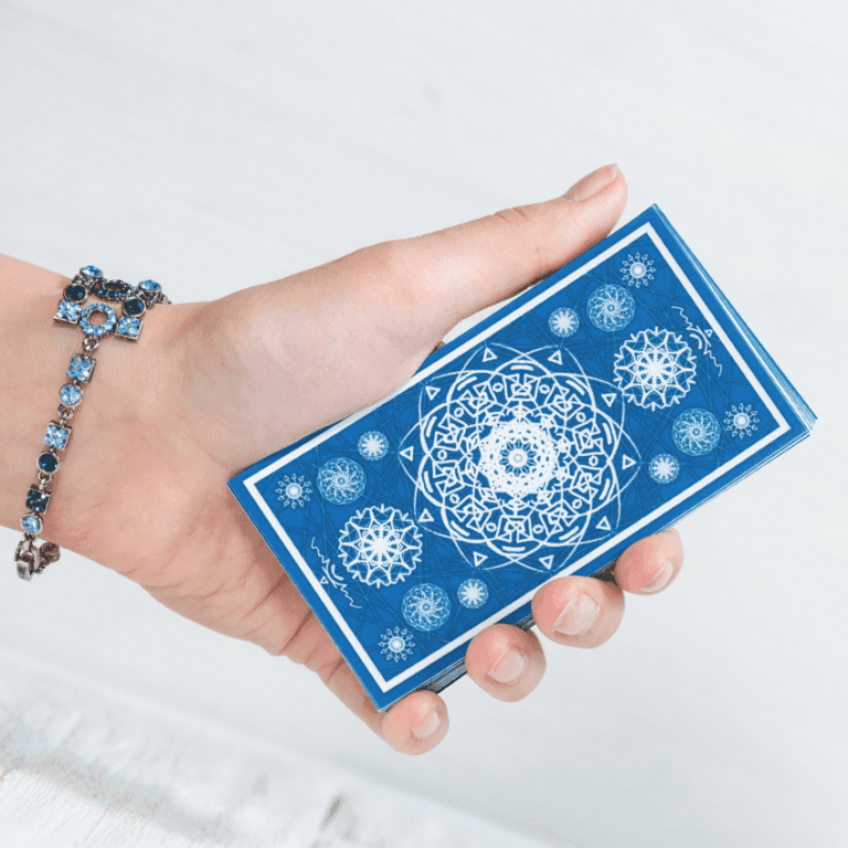 A hand holds a blue Tarot card.